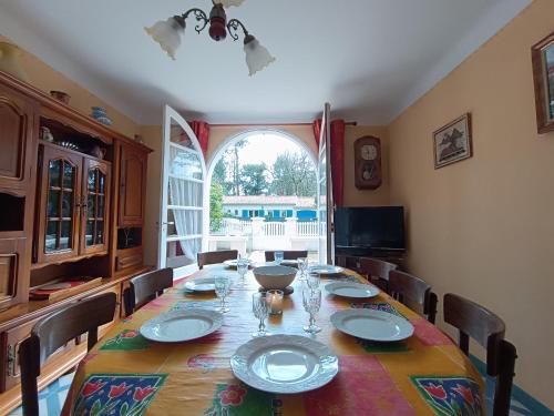 une salle à manger avec une longue table et des chaises dans l'établissement Maison traditionnelle à Saint Brevin, 850m plage, lumineux séjour, jardin, 4 ch., garage, animaux OK - FR-1-364-66, à Saint-Brévin-les-Pins