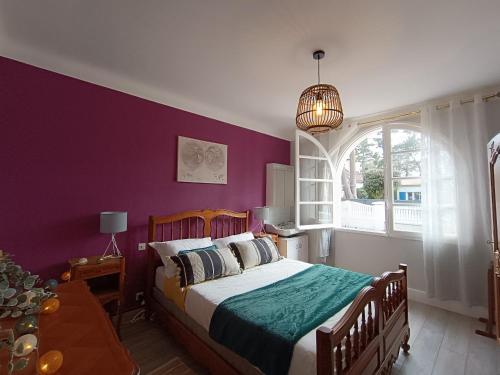 - une chambre avec un lit et un mur violet dans l'établissement Maison traditionnelle à Saint Brevin, 850m plage, lumineux séjour, jardin, 4 ch., garage, animaux OK - FR-1-364-66, à Saint-Brévin-les-Pins