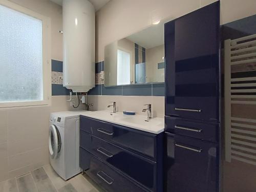 une salle de bain avec un lavabo et une machine à laver dans l'établissement Maison traditionnelle à Saint Brevin, 850m plage, lumineux séjour, jardin, 4 ch., garage, animaux OK - FR-1-364-66, à Saint-Brévin-les-Pins