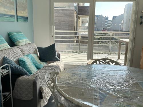 un salon avec une table et un canapé dans l'établissement Appartement familial près de la plage avec parking et balcon verdoyant - FR-1-482-49, à Fort-Mahon-Plage