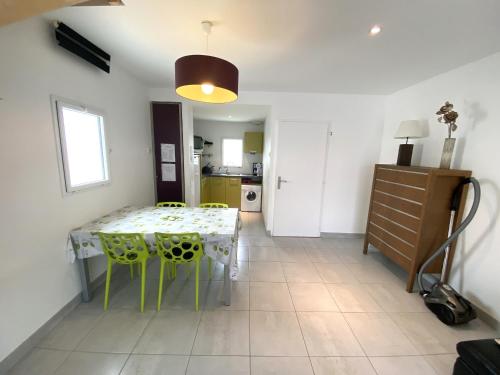 une cuisine et une salle à manger avec une table et des chaises dans l'établissement Maison neuve à 600m de la plage, terrasse avec pergola, parking, équipements modernes - FR-1-22-298, à La Tranche-sur-Mer