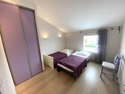 une chambre d'hôpital avec deux lits et une chaise dans l'établissement Maison neuve à 600m de la plage, terrasse avec pergola, parking, équipements modernes - FR-1-22-298, à La Tranche-sur-Mer