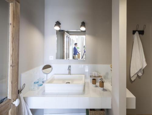 een witte badkamer met een wastafel en een spiegel bij Villa Caroline - Chambres d'Hôtes in Albi