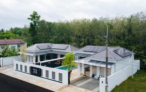Nue Hatyai Pool Villa في هات ياي: اطلالة جوية على منزل به لوحات شمسية على السطح