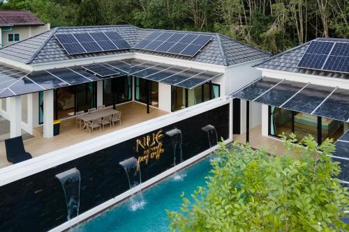 Nue Hatyai Pool Villa في هات ياي: اطلالة جوية على منزل عليه لوحات شمسية