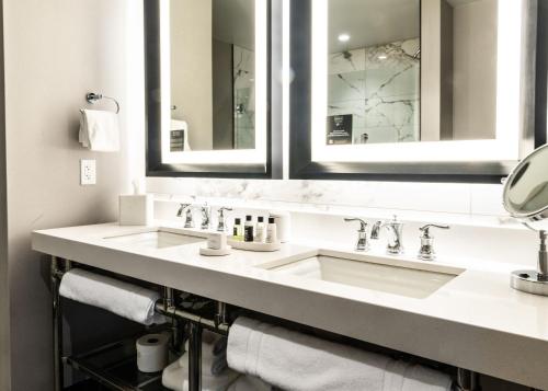 a bathroom with two sinks and two mirrors at Foundry Hotel Asheville, Curio Collection By Hilton in Asheville