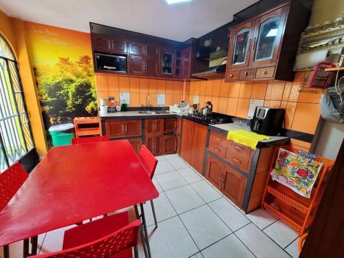 eine Küche mit einem roten Tisch und roten Stühlen in der Unterkunft Jaichi Saitama in Cajamarca