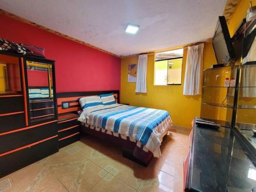 ein Schlafzimmer mit einem Bett und einem Fernseher in der Unterkunft Jaichi Saitama in Cajamarca