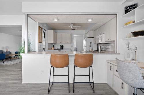 a kitchen with two chairs at a counter at Venice Lakefront Pool Home in Venice