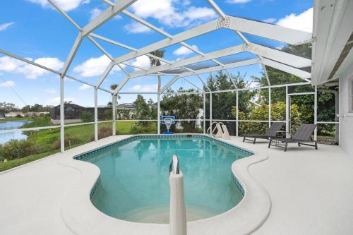 an indoor swimming pool with a large pergola at Venice Lakefront Pool Home in Venice