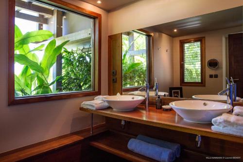 a bathroom with two sinks and a large mirror at Luxury Vacation Villa 6 in Pointe Milou