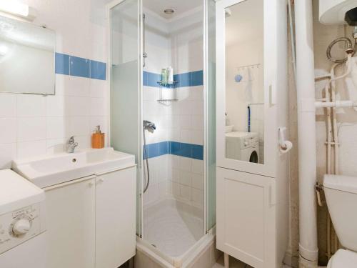 une salle de bain blanche avec une douche et un lavabo dans l'établissement Pavillon 5 couchages avec piscine proche plage, terrasse et parking privé à Gruissan - FR-1-409-231, à Gruissan