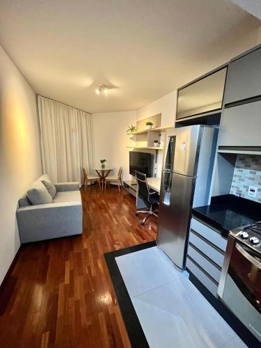 a kitchen and living room with a couch and a refrigerator at Flat Premium -Acesso a pé ao shopping Center vale - Edifício Summit (Ar condicionado) in São José dos Campos