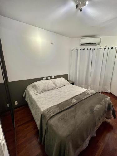 a bedroom with a bed in a room at Flat Premium -Acesso a pé ao shopping Center vale - Edifício Summit (Ar condicionado) in São José dos Campos