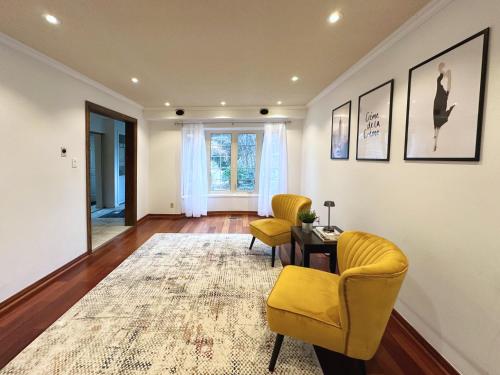 Sala de estar con 2 sillas amarillas y mesa en Elegant Spacious 4BR House in Upscale Neighborhood, en Richmond Hill