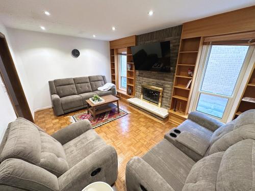 sala de estar con 2 sofás y chimenea en Elegant Spacious 4BR House in Upscale Neighborhood, en Richmond Hill
