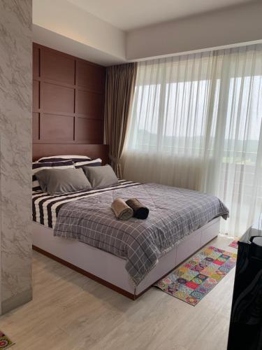 a bedroom with a bed and a large window at Golf Resort View at Kaina Tower Nuvasa Bay 9B22 in Nongsa