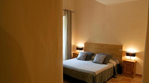 a bedroom with a bed with two pillows on it at Logis Hôtel Restaurant Le Domaine de l'Eau Vive in Largentière
