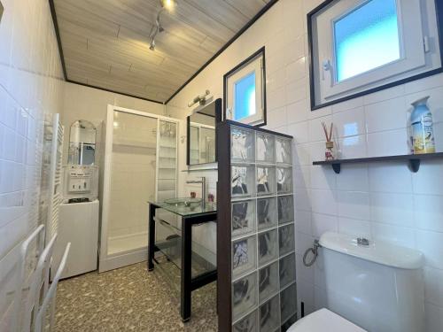 a bathroom with a toilet and a sink and a window at Maison avec WIFI, véranda, à 320m de la mer et à 500m de la plage, à Trégastel - FR-1-368-408 in Trégastel