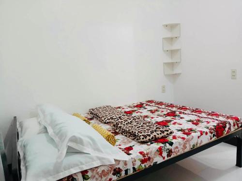 a bed with a red and white quilt on it at LR Hostel and Cafe in Moalboal