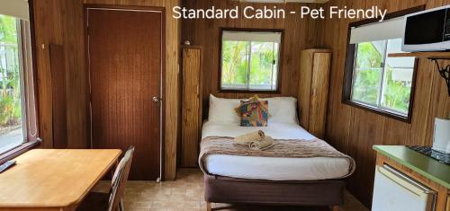 un pequeño dormitorio con una cama con un osito de peluche. en River Retreat Home & Holiday Park, en Tweed Heads
