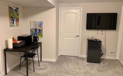 Habitación con nevera, mesa y puerta en Fully Furnished En-Suite Basement, en Ottawa