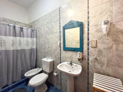 a bathroom with a toilet and a sink and a mirror at Aguamarina in Las Grutas