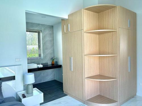 - une chambre avec un grand placard en bois dans l'établissement Costa Lota villa, brand new, 3 bedroom, in rawai V35, à Ban Saiyuan (1)