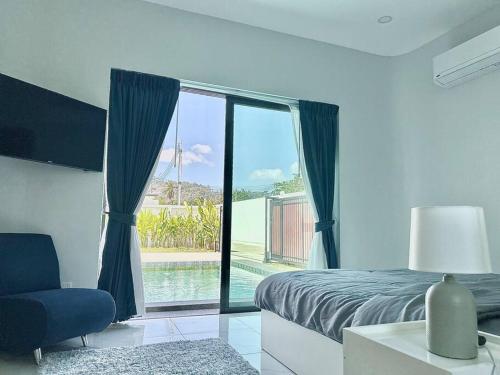 une chambre avec un lit et une vue sur une piscine dans l'établissement Costa Lota villa, brand new, 3 bedroom, in rawai V35, à Ban Saiyuan (1)