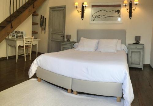 Un dormitorio con una gran cama blanca y una mesa en Provencal farmhouse, pool, pool house, countryside Plan d’Orgon, Provence - 8 people, en Cavaillon