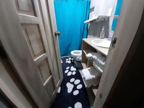 une porte ouverte menant à une salle de bains pourvue de toilettes et d'un lavabo. dans l'établissement ENCALADA, à Otavalo