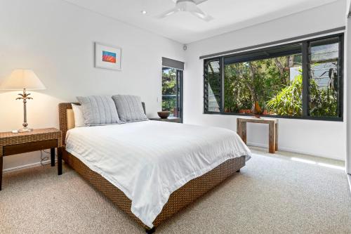 a bedroom with a large bed and a window at Laidback luxury living, Noosa Heads in Noosa Heads