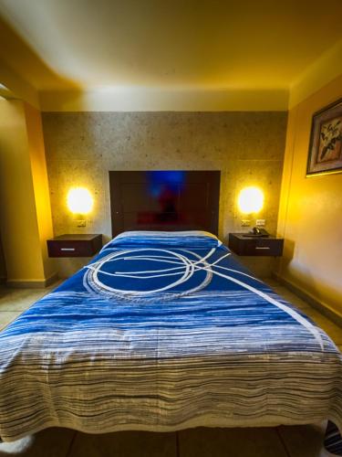 a large bed in a room with two lamps at Hotel Oasis in Ciudad Constitución