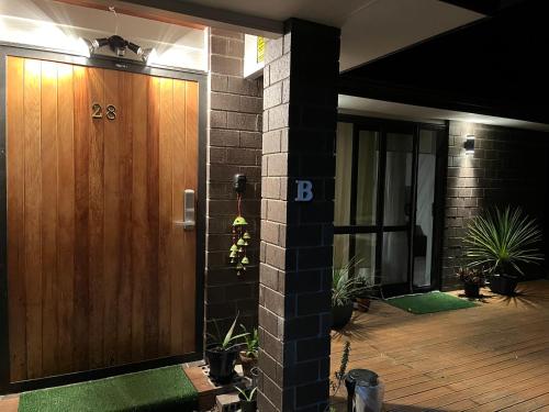 a front door of a house with a wooden door at Comfy Stay in Room with Security & Privacy - Room 102 in Auckland