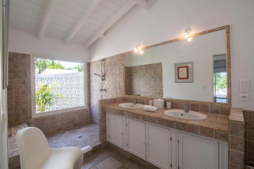 een badkamer met 2 wastafels en een grote spiegel bij Luxury Vacation Villa 7 in Les Terres Basses
