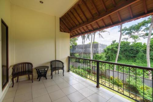 a balcony with two chairs and a table and a view at Champlung Sari Hotel and Spa Ubud in Ubud