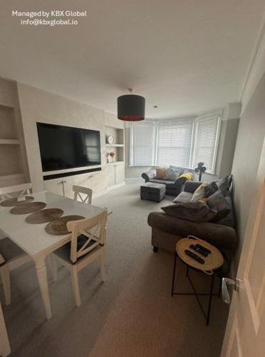 een woonkamer met een bank en een tafel bij Luxurious New Serviced Apartment (Surrey) in Redhill