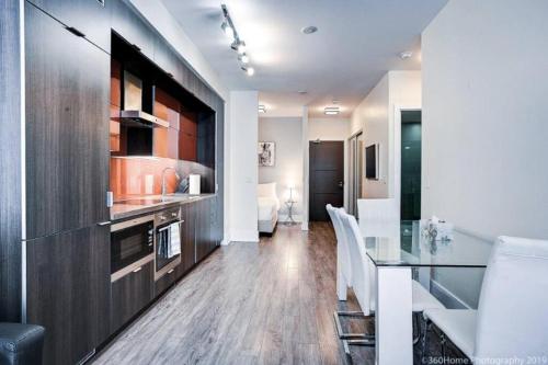 a kitchen and dining room with a glass table at Luxury 2 Bedroom Downtown in Toronto
