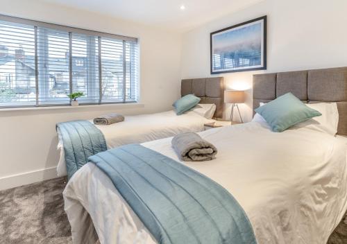 卡地夫的住宿－Hafan y Ddinas Cardiff Apartment 2，一间卧室设有两张床和两个窗户。