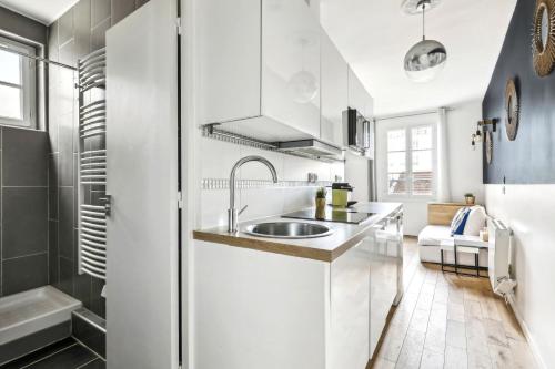 - une cuisine blanche avec un évier et une douche dans l'établissement Charming top floor near Montmartre, à Paris