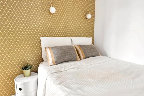 - une chambre avec un lit blanc et un mur dans l'établissement Charming top floor near Montmartre, à Paris