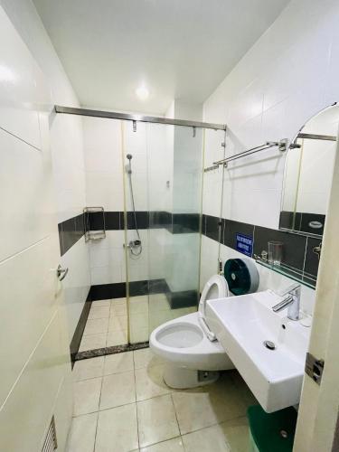 uma casa de banho com um chuveiro, um WC e um lavatório. em LATALAND HOSTEL em Cidade de Ho Chi Minh