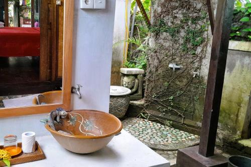 a bowl sitting on a counter in front of a bathroom at Pondok Pisces Bungalows Balian Beach in Selemadeg