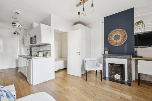 un salon avec cheminée et une cuisine dans l'établissement Charming top floor near Montmartre, à Paris