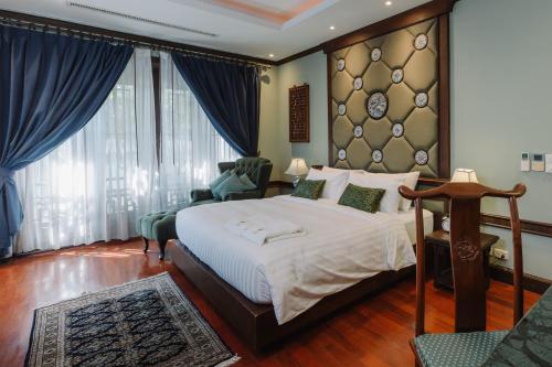 a bedroom with a large bed and a large window at Lunar Mansion Hotel in Chiang Mai