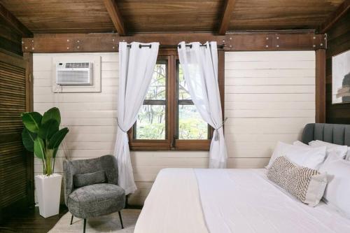 1 dormitorio con cama, ventana y silla en Stunning Cottage with Ocean Views Near Beaches, en Enighed
