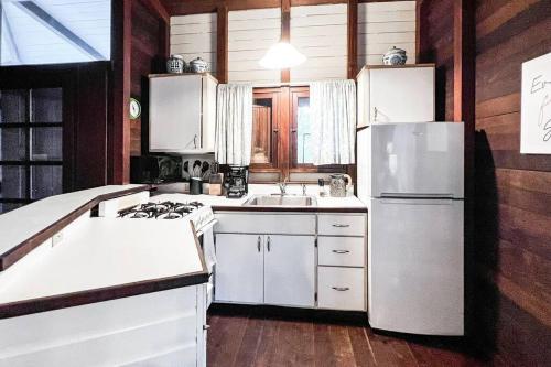 a kitchen with white appliances and a white refrigerator at Stunning Cottage with Ocean Views Near Beaches in Enighed