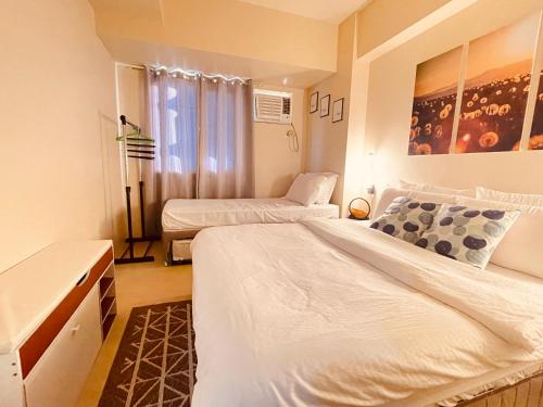 1 Schlafzimmer mit 2 Betten und einem Fenster in der Unterkunft Centrio Tower 1 Bedroom in Cagayan de Oro