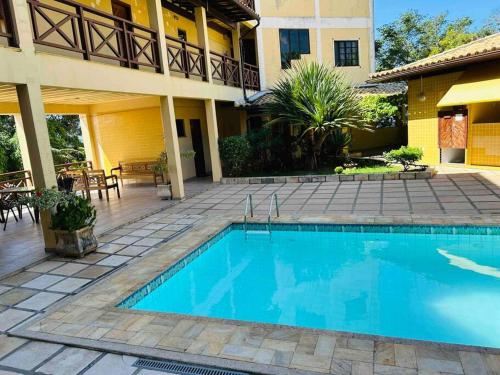 une piscine en face d'un bâtiment dans l'établissement Iguaba Grande, 3 minutos do mar, à Iguaba Grande