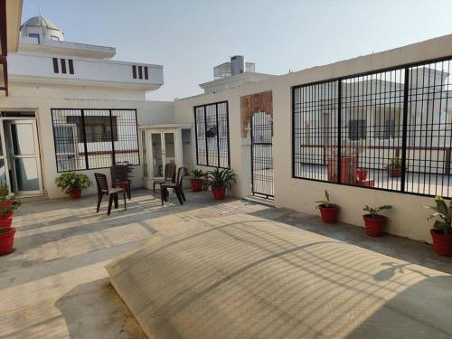 un edificio con un patio con sedie e finestre di Shantiniketan - Comfortable Stay in Ayodhya a Ayodhya